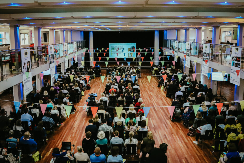 Conference attendees in a large hall.